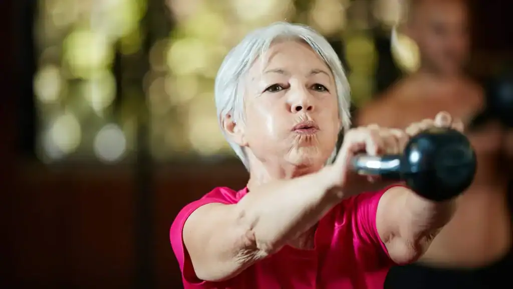 Toning Arms After 60: Empowering Womens Fitness Through Effective Weight Training 1 Older woman doing weight training Romford to help her strength and longevity