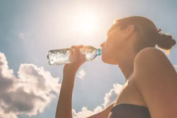 Hydration: The Secret Ingredient for a Toned Stomach and Enhanced Fitness 3 Image of woman drinking water to hydrate Romford after run.