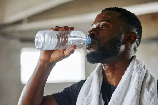 Hydration: The Secret Ingredient for a Toned Stomach and Enhanced Fitness 1 Image of man drinking water to improve hydration Romford after work out.